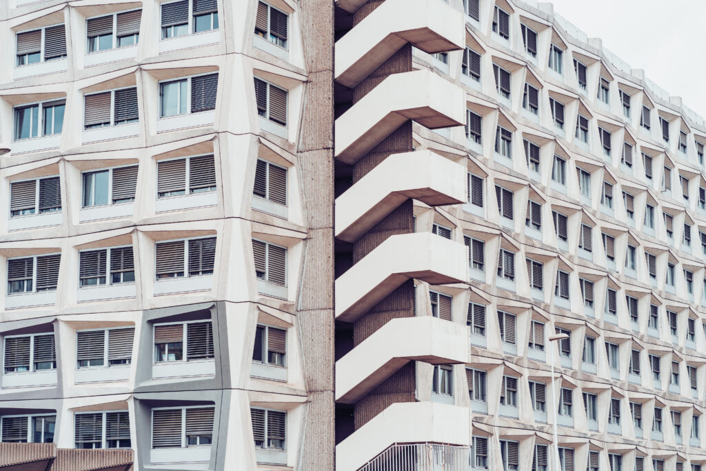 Exterior of a high-rise residential building with staircases but no visible lift access, highlighting architectural barriers in older public housing.