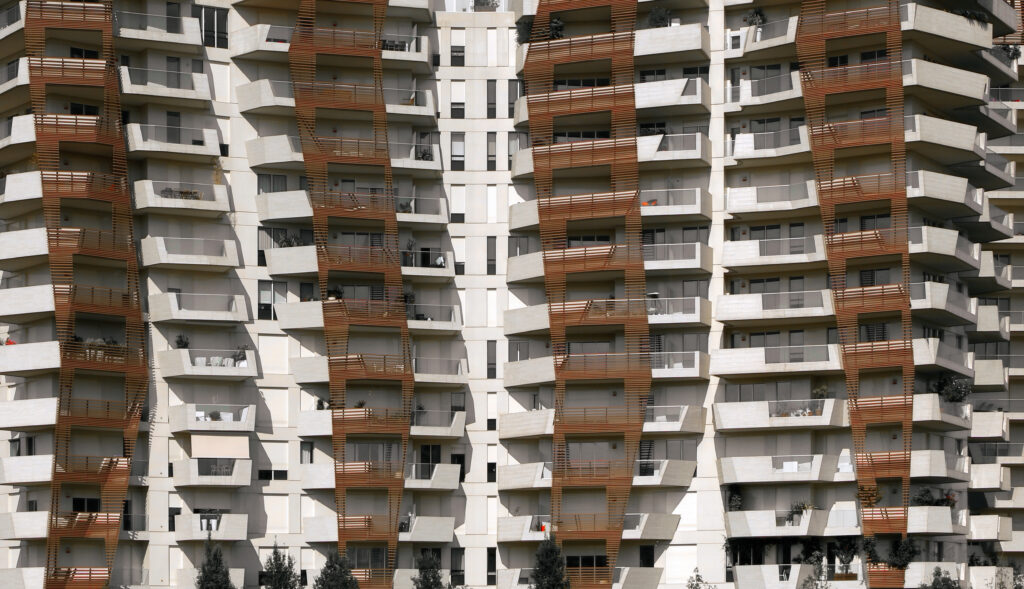 Modern high-rise residential apartment building with white and brown spiral balcony design.